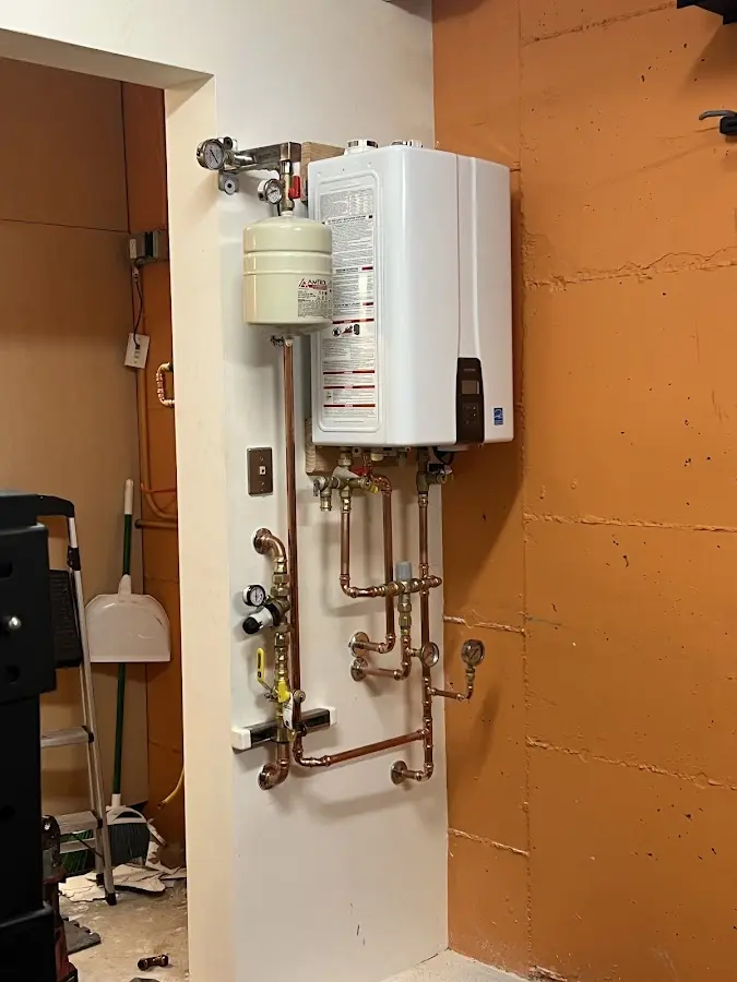 Plumbing technician inspecting water heater connections in Jackson
